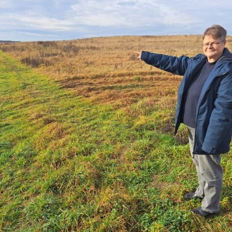 Christine Jantzen, Ehrenamtliche Bürgermeisterin von Kieve. Christine Jantzen, Ehrenamtliche Bürgermeisterin von Kieve zeigt auf den Acker für die PV-Anlage